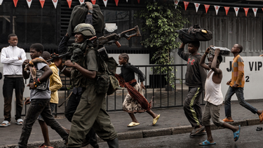 Un miembro del grupo armado M23 camina junto a los residentes por una calle del barrio de Keshero en Goma, el 27 de enero de 2025.