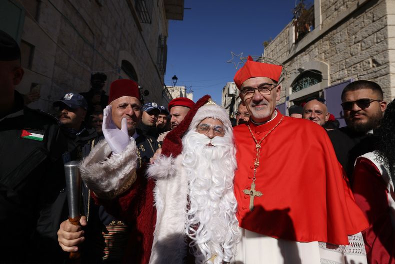&nbsp;Patriarca latino de Jerusalén, Pierbattista Pizzaballa, posa con un hombre vestido de Papá Noel.